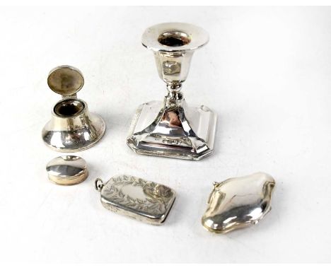 Various hallmarked silver items comprising a squat candlestick, a lidded inkwell, small lidded pill box, coin purse and vesta