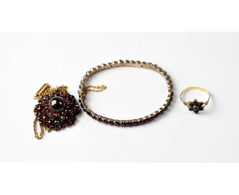 Three garnet cluster jewellery items to include a bracelet with a line of claw set garnets, with box clasp and gold safety ch