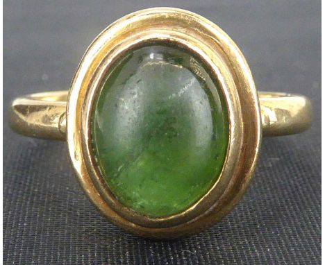 A 9ct gold emerald ring, the half emerald cabochon of oval form, in a bezel set lipped mount, on an 9ct yellow gold shank, si