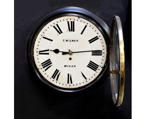 T. MILNER OF WIGAN; a late 19th century circular station clock in ebonised frame, the cream dial set with Roman numerals, dia