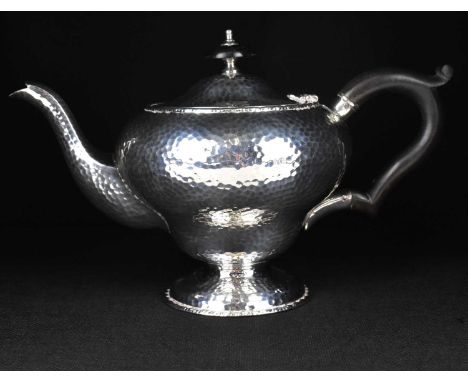 ROBERT CHANDLER; a George V hallmarked silver bachelor teapot with reproduction all-over hammered effect, raised on circular 