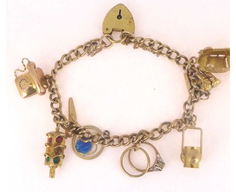 A gold plated charm bracelet with seven 9ct gold charms, one silver and enamel charm, and rolled gold padlock clasp, length 1