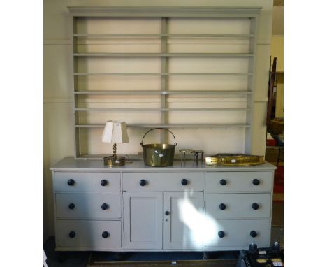 A grey painted Victorian pine large farmhouse dresser base with seven drawers and two cupboard doors with turned knob handles
