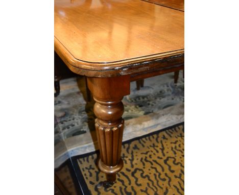 Large 19th Century rectangular mahogany extending dining table raised on turned tapering fluted supports with brass and ceram