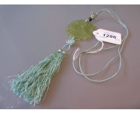 Early 20th Century Chinese carved and pierced pale green jade pendant on a green silk tasselled cord