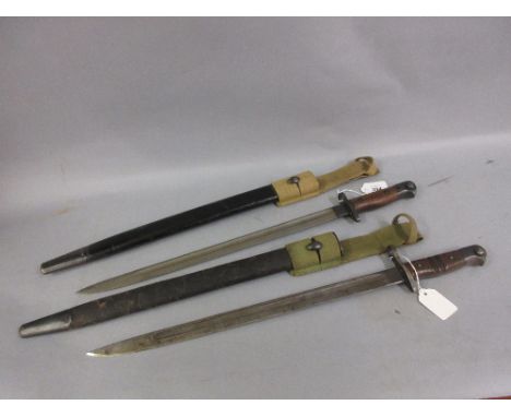 Two early 20th Century bayonets with scabbards, one inscribed Wilkinson 1907 and the other Remington 1913