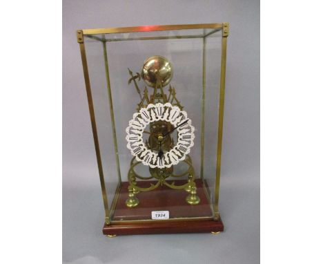 Brass Gothic style skeleton clock having a single train movement striking on a bell with white painted pierced chapter ring a