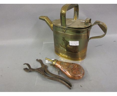 Embossed copper powder flask decorated with game and hunting dog, a steel bottle opener and a brass watering can