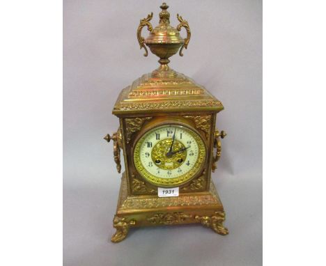 Late 19th Century gilt brass mantel clock of ornate design, the rectangular case with an urn surmount and shaped side handles