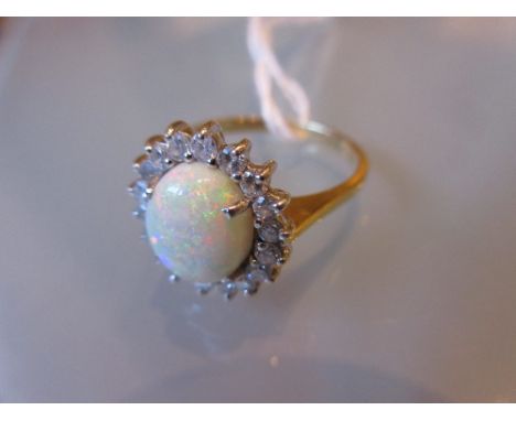 18ct Yellow gold opal and diamond cluster ring, the opal of approximately 10mm x 7mm within a brilliant cut diamond surround