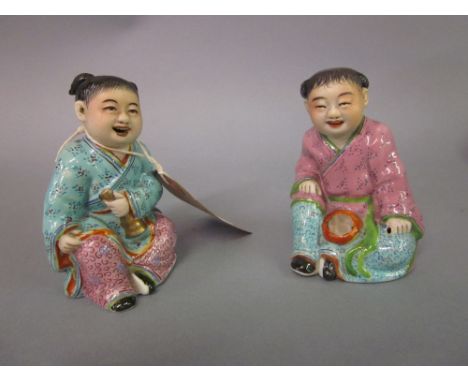 Pair of Chinese porcelain figures of seated children, one signed with seal mark to base