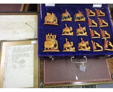 20th Century Indian carved wooden, painted and gilt figural chess set in velvet case, an antique framed indenture and a print