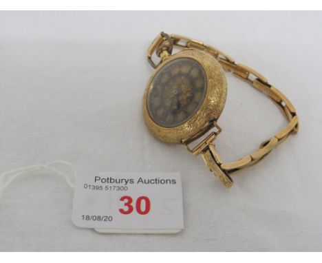 AN 18 CARAT IMPORTED GOLD FOB WATCH WITH A GOLD-PLATED PATENT EXPANDING BRACELET, THE WATCH WITH FOLIATE CHASING AND VACANT E
