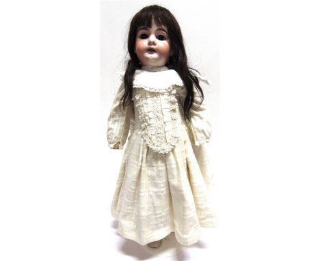 AN ARMAND MARSEILLE BISQUE SOCKET HEAD DOLL  with a long dark brown wig, sleeping brown glass eyes, and an open mouth with fo