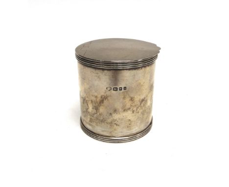 A SILVER TEA CADDY  by the Goldsmiths & Goldsmiths Co Ltd, London 1934, of drum shape, flat hinged cover, with reeded rims, 8