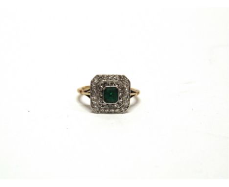 AN EMERALD AND DIAMOND CLUSTER PANEL RING stamped '18ct & Pt', the step cut measuring approximately 4.5mm by 3.8mm by 2.7mm d