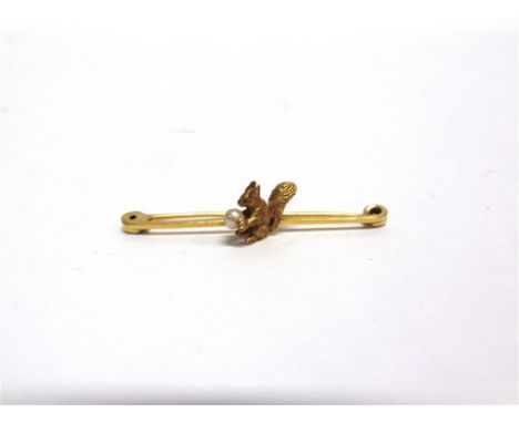 A SQUIRREL BAR BROOCH stamped '15ct', holding a simulated pearl 'nut' in its paws, 4.9cm long, 3.9g gross