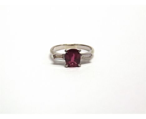 A RUBY AND DIAMOND THREE STONE RING unmarked, the oval cut stone approximately 7.6mm by 6.7mm by 3.1mm deep, with a tapering 