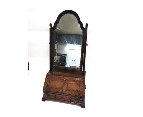 AN UNUSUAL OAK TOILET MIRROR  the bureau base with fitted interior above moulded drawer on ogee bracket feet, 39cm wide 25cm 