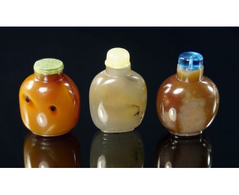 A Chinese carved agate snuff bottle, 19th century, raised on cylindrical foot, jade stepped stopper, 8 cm high; together with
