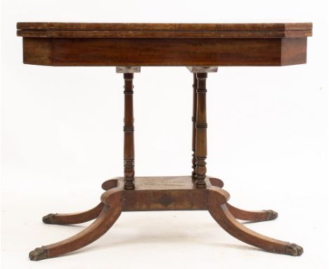 AN EARLY VICTORIAN MAHOGANY FOLDOVER CARD TABLE  with canted corners, four turned column supports and splaying legs terminati