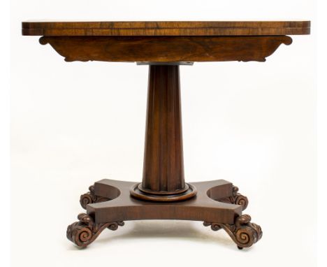 A VICTORIAN ROSEWOOD FOLD OVER CARD TABLE with central fluted column support, platform base and carved scroll feet, 91cm wide