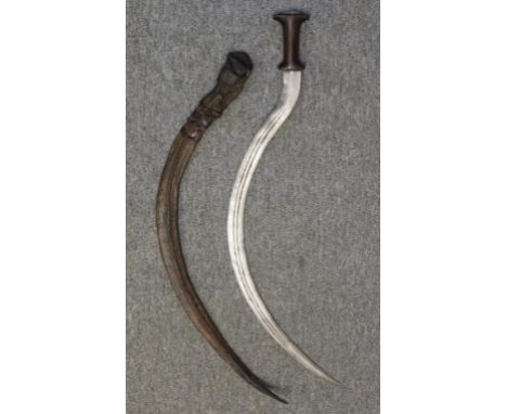 with characteristically curved double-edged blade formed with pair of fullers, rhinoceros horn hilt, silver pommel button, in