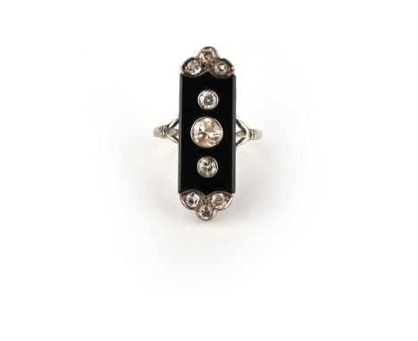 An Art Deco onyx and diamond white gold ring, circa 1920, designed as a polished onyx plaque, the centre inset with three mil