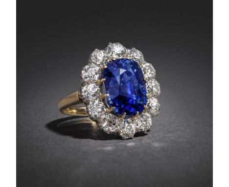 A late Victorian sapphire and diamond cluster ring, the cushion-shaped sapphire weighs 7.56cts and is set within a surround o