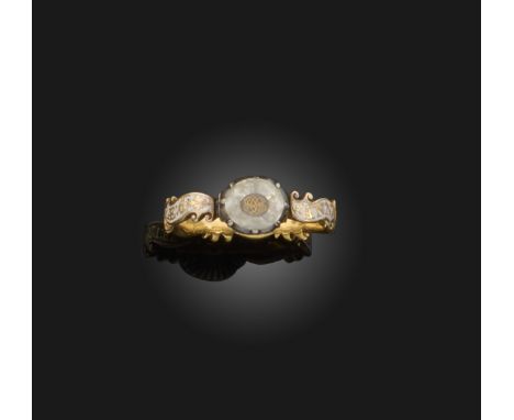 A mid 18th century gold mourning ring, set with an oval-shaped rock crystal above woven initials, on a white enamel band with
