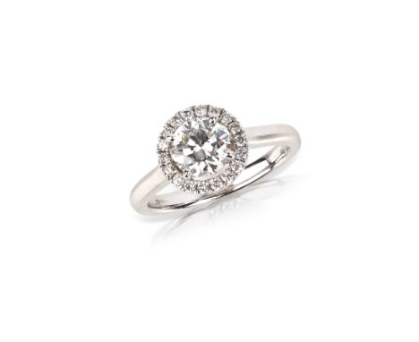 A diamond ring, of halo design in 18ct white gold, centring on a brilliant-cut diamond weighing 1.06 carats, within a border 