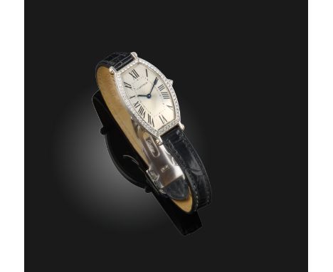 A lady's diamond wristwatch, 'Tonneau', Cartier, the elongated silvered dial with Roman numeral indicators and blued steel ha