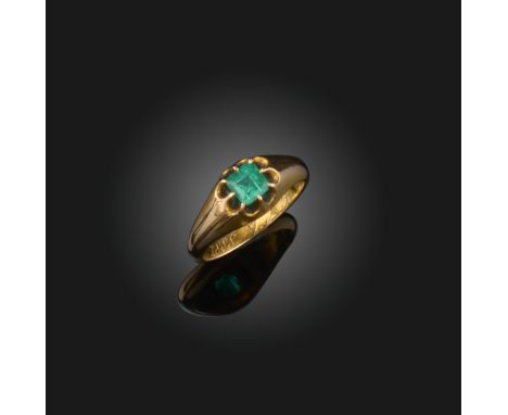 An emerald solitaire ring, late 19th century, claw-set with a step-cut emerald, to a plain gold band, inscribed 'ACB July 1st