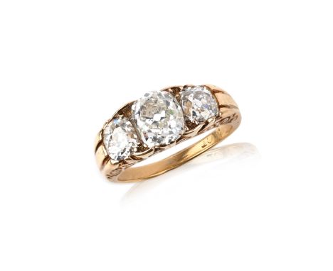 A late Victorian diamond three-stone ring, set with an oval diamond between smaller cushion-shaped diamonds, the gold mount a