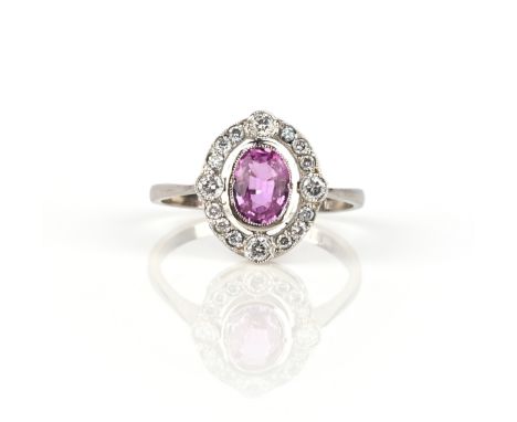 A pink sapphire and diamond ring, set with an oval pink sapphire weighing 0.90 carats, within an open work oval border of bri