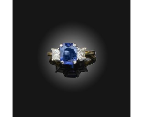 A sapphire and diamond ring, claw-set with a mixed-cut sapphire weighing 2.84 carats, between shoulders set with princess-cut