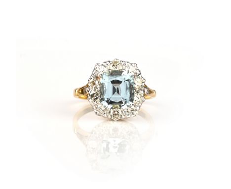 An aquamarine and diamond ring, claw-set with a cushion-shaped aquamarine weighing 2.25 carats, within a border of brilliant-