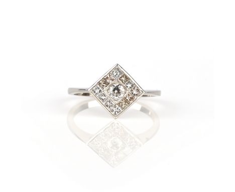 A diamond set platinum ring, set with a circular-cut diamond within a lozenge-shaped border channel-set with princess-cut dia