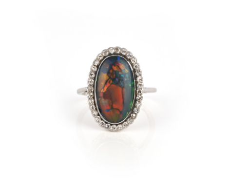 An Edwardian opal and diamond cluster ring, the oval-shaped solid black opal is set within a surround of single-cut diamonds 