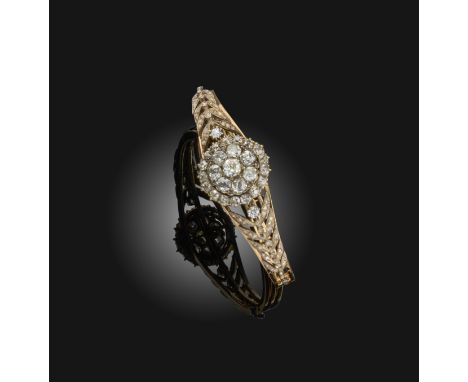 A Victorian diamond-set gold bangle, set with a central cluster of old cushion-shaped diamonds within diamond-set laurels in 