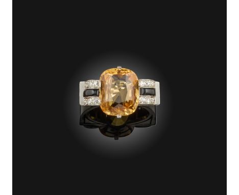 A French sapphire and diamond scroll ring, set with a cushion-shaped orange sapphire, weighing approximately 8.50cts, within 