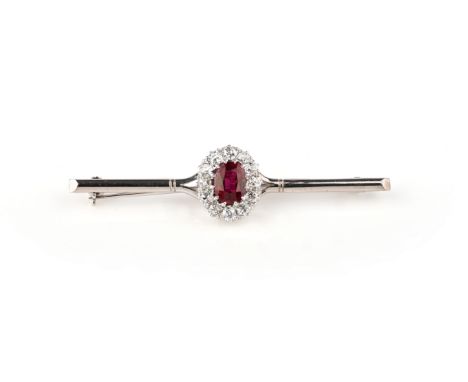 A ruby and diamond cluster brooch, the oval-shaped ruby is set within a surround of old cushion-shaped diamonds in 18ct white