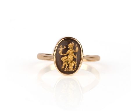 A gold and rock crystal reverse intaglio ring, collet-set with an oval rock crystal cabochon carved and gilded to the reverse