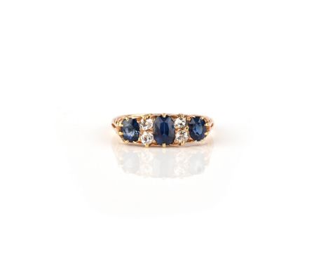 A sapphire and diamond ring, late 19th century, set with three oval sapphires, spaced by pairs of cushion-shaped diamonds, th