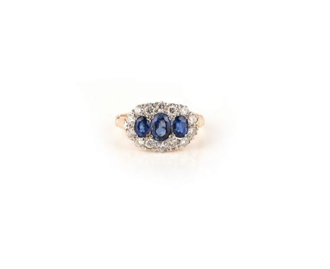 A sapphire and diamond ring, designed as three oval sapphires within a border of brilliant-cut diamonds, size K1/2, British h