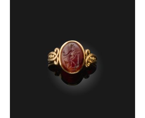 A Roman carnelian intaglio, 1st-2nd century AD, of oval outline, engraved with a figure of Mars beside a half column, wearing