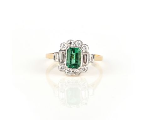 An emerald and diamond ring, set with a step-cut emerald weighing 0.50 carats, to a millegrain-set border of brilliant-cut an