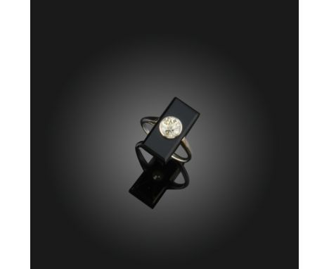 An Art Deco diamond and black onyx ring,  the old circular cut diamond is millegrain set in a rectangular onyx plaque and whi