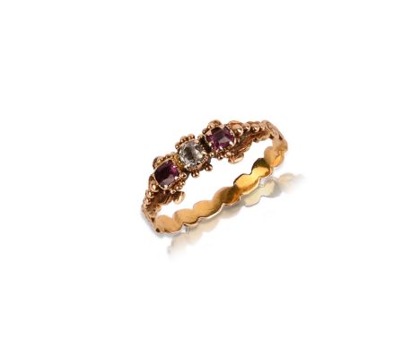 A Georgian ruby and diamond gold ring, early 19th century, set with a cushion-shaped diamond between cushion-shaped rubies, a