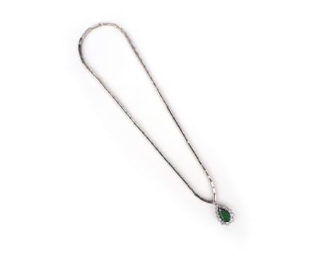 An emerald and diamond pendant, set with a pear-shaped emerald within a surround of diamonds in white gold on a white gold ne